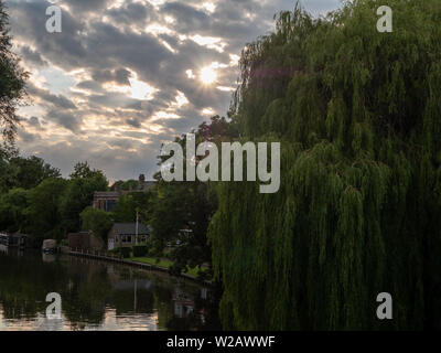 River Cam, Cambridge, England, UK - The sun sets through clouds over the river Cam with a Willow tree in the foreground Stock Photo