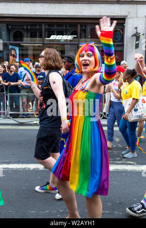 6 July 2019 - Couple holding hands, rainbow coloured costume, London Pride Parade, UK Stock Photo