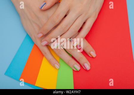 Modern stylish manicure rainbow or summer mood, on a blue table with color envelopes Stock Photo
