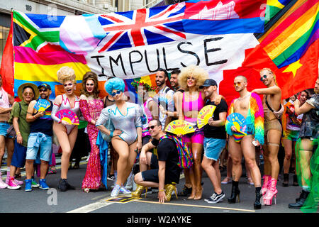 6 July 2019 - A group of drag queens posing in front of Impulse banner, London Pride Parade, UK Stock Photo