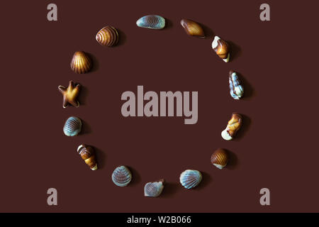 Assorted Chocolate pralines with sea concept on brown background. Stock Photo