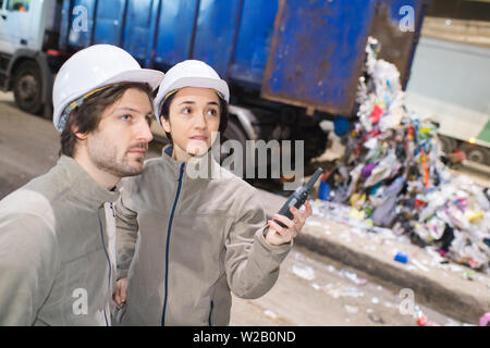 recycling plant workers talking in walkie-talkie Stock Photo