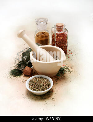 Vintage mortar and pestle with spices and herbs on white canvas table cloth Stock Photo