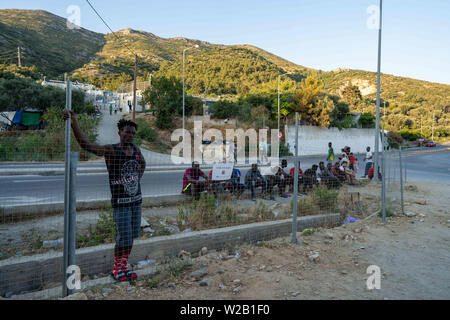Samos, Samos, Greece. 28th June, 2019. A group of migrants living in or around the migrant camp on Samos gather to watch a game of football between players from Cameroon and the Democratic Republic of Congo. Samos Island is one of Europe's migrant hotspots acting as a reception and identification centre (RIC). It was established as a temporary accommodation site where migrants could be processed before moving to a refugee camp on the mainland. However, due to the continued number of arrivals, the mainland camps are full and so migrants are being left at the islands. The conditions are inhu Stock Photo