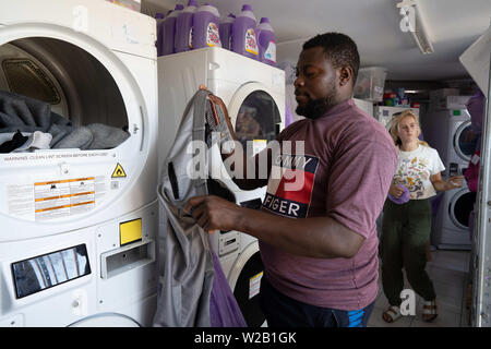 Samos, Samos, Greece. 28th June, 2019. An NGO worker washes clothes for the residents on Samos. Residents have to wait for 3 months between clothes washes.Samos Island is one of Europe's migrant hotspots acting as a reception and identification centre (RIC). It was established as a temporary accommodation site where migrants could be processed before moving to a refugee camp on the mainland. However, due to the continued number of arrivals, the mainland camps are full and so migrants are being left at the islands. The conditions are inhuman as the Central Government has for several years i Stock Photo