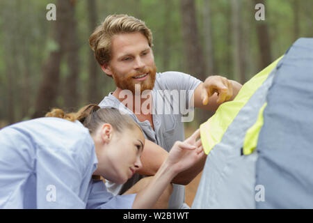 a nice couple sets up a tent Stock Photo