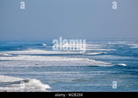 surfers in the ocean off the coast of Huntington Beach, California Stock Photo