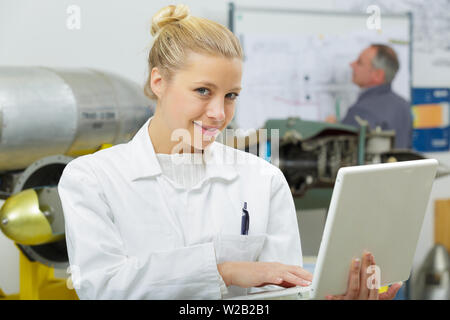 female engineer holding laptop in aviation design room Stock Photo