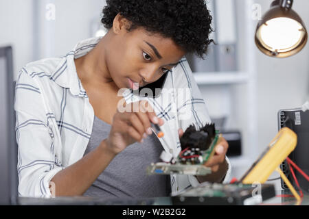 female on the phone fixing a computer Stock Photo