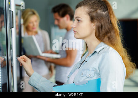 woman pushing button on vending machine Stock Photo