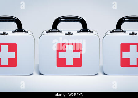 First aid kits with cross emblems in a row on light grey background Stock Photo