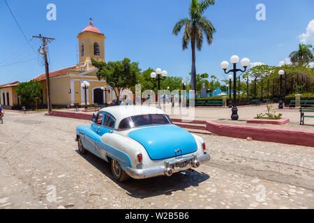 Trinidad, Cuba - June 6, 2019: View of an Old Classic American Car in the streets of a small Cuban Town during a vibrant sunny day.