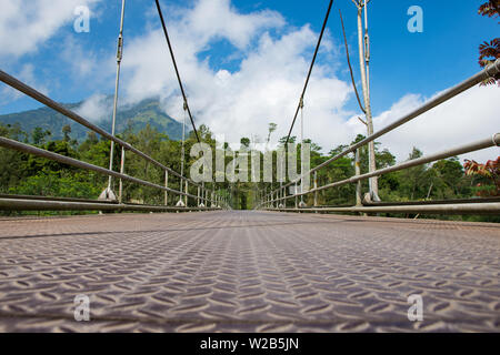 Low angle of view from a foot bridge looking up towards mountain peak Stock Photo