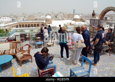 Tunisians taking in a rooftop view of the Tunis old city and medina overlooking the Zeitoun mosque, seen from an outdoor cafe, Tunisia. Stock Photo