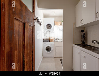 Laundry room interior. Utility room with washing machine, cleaning  equipment, home cleaners, clean wipes, hanging colorful shirts on  clothesline on wh Stock Photo - Alamy