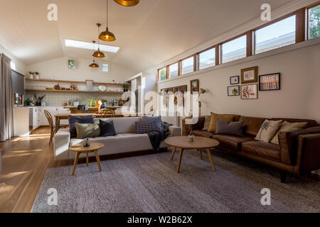 Open plan living, dining and kitchen in a country home with a vaulted ceiling and highlight windows Stock Photo