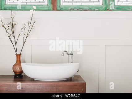 Country bathroom with a stone sink, silver tap ware, wainscoting on a jarrah bench top Stock Photo