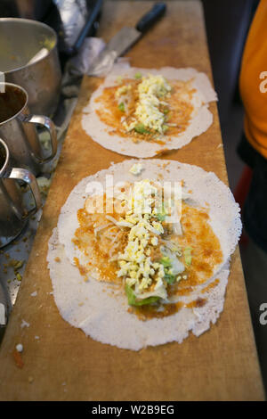 Popiah or known as spring roll, filled with ingredients such as egg, greens, sauce, peanuts, carrots, garlic, turnip, bean sprots etc. Stock Photo