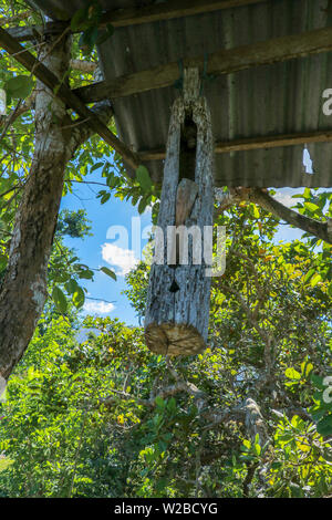 Wooden bells kulkul. A wooden bell with a mallet made from a tree trunk hung on a beam between trees on Bali Island. Balinese Hindus make bell Stock Photo