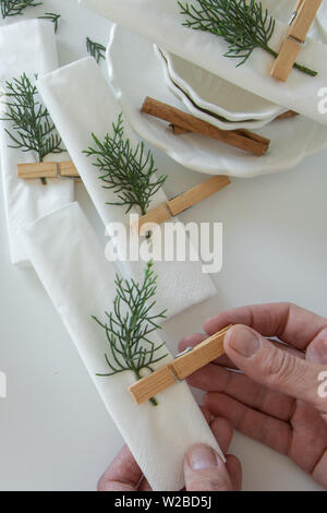 Top view of woman hands preparing and arranging the table for winter holidays. Winter decoration, DIY Stock Photo