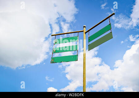 Vintage street sign on ofne blue sky with clouds. Direction guidance concept. Copy space. Stock Photo