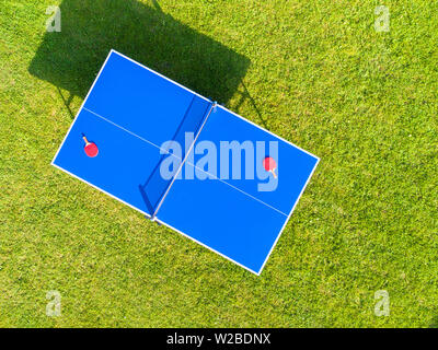 Aerial view blue table tennis or ping pong. Close-up ping-pong net. Close up ping pong net and line. Top view two table tennis or ping pong rackets or Stock Photo