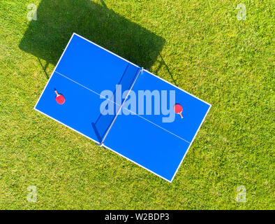 Aerial view blue table tennis or ping pong. Close-up ping-pong net. Close up ping pong net and line. Top view two table tennis or ping pong rackets or Stock Photo