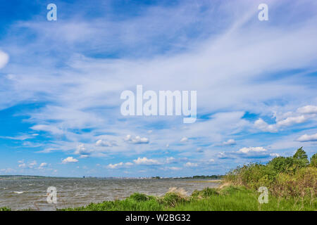 Summer landscape - Cumulus and Cirrus in the blue sky over the lake. Stock Photo