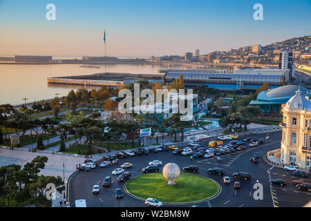 Azerbaijan, Baku, View of traffic at roundabout on Neftchilar Ave, looking towards Baku bay, Venezia restaurant, the Carpet museum, in the distance is Baku Crystal Hall, where the 2012 Eurovision Song Contest was held - and the World's second Tallest Flagmast Stock Photo