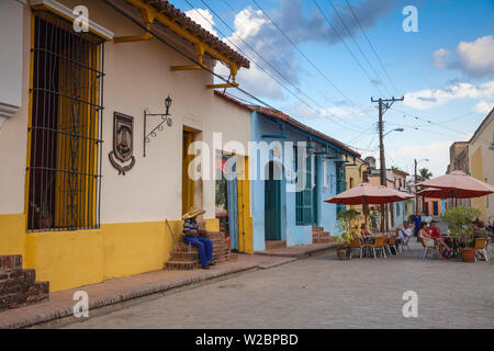Cuba, Camaguey, Camaguey Province, Plaza San Juan de Dios, Ederly man sitting on  steps smoking Cuban cigar