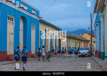 Cuba, Trinidad, Children walking past Classic American car on way to school Stock Photo