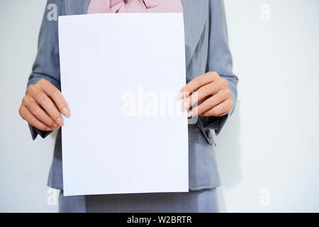 Cropped image of female entrepreneur holding blank white paper sheet Stock Photo