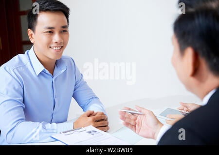 Portrait of young smiling Asian man attending job interview Stock Photo