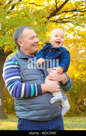 father and baby walking in autumn park Stock Photo