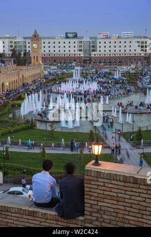 Iraq, Kurdistan, Erbil, Men sitting on walls at Citadel looking over Shar park (City Center Park) and Qaysari Bazaars Stock Photo