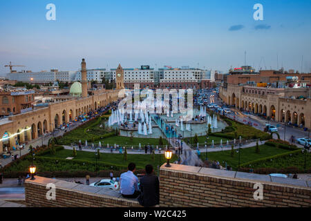 Iraq, Kurdistan, Erbil, Men sitting on walls at Citadel looking over Shar park (City Center Park) and Qaysari Bazaars Stock Photo