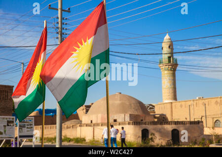 Iraq, Kurdistan, Erbil, The Citadel, Men walking past mosque and Kurdish flag Stock Photo