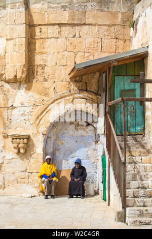 Israel, Jerusalem, The courtyard of the Church of the Holy Sepulchre, Men sitting outside door to Coptic church Stock Photo