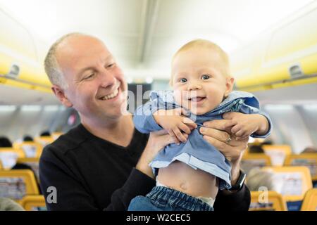 Father standing with his six months old baby boy in the airplane, Spain Stock Photo