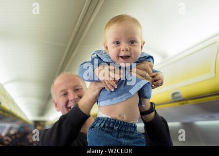 Father standing with his six months old baby boy in the airplane, Spain Stock Photo