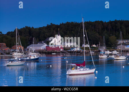 USA, Maine, Boothbay Harbor, harbor view with Our Lady Queen of Peace Catholic Church, dusk Stock Photo