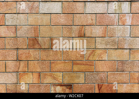 Old orange brick wall, texture of orange stone blocks closeup. Wall texture Stock Photo