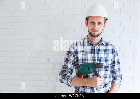 Civil engineer wearing safety helmet holding drill in his hand. Stock Photo