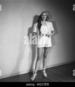 1940s summer outfit. A young blonde woman wears a pair of whit shorts and a jacket. Sweden 1947 Kristoffersson Z26-4 Stock Photo