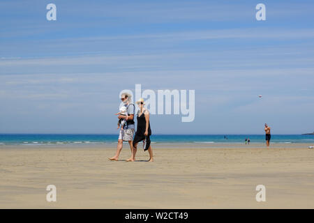 Young family walking on the beach in Cornwall Stock Photo