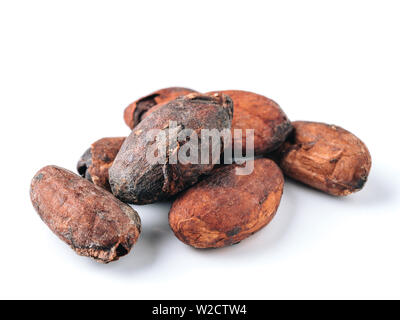 Raw cacao beans top view on white background. Close up view of raw cacao beans isolated on white with clipping path. Stock Photo