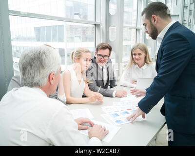Group of business people discussing diagrams in office together Stock Photo