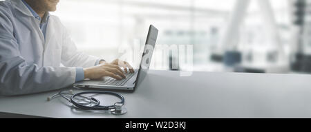 doctor working on laptop computer in modern clinics office. copy space Stock Photo