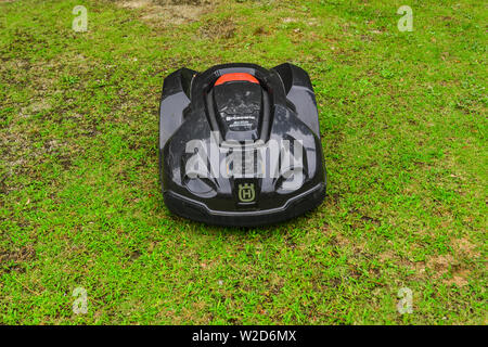 Nagoya, Japan - Jun 29, 2019. Automatic lawn mower robot moves on the grass at botanic garden. Stock Photo