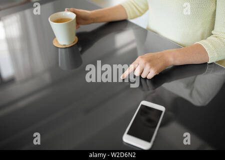 woman with coffee using black interactive panel Stock Photo